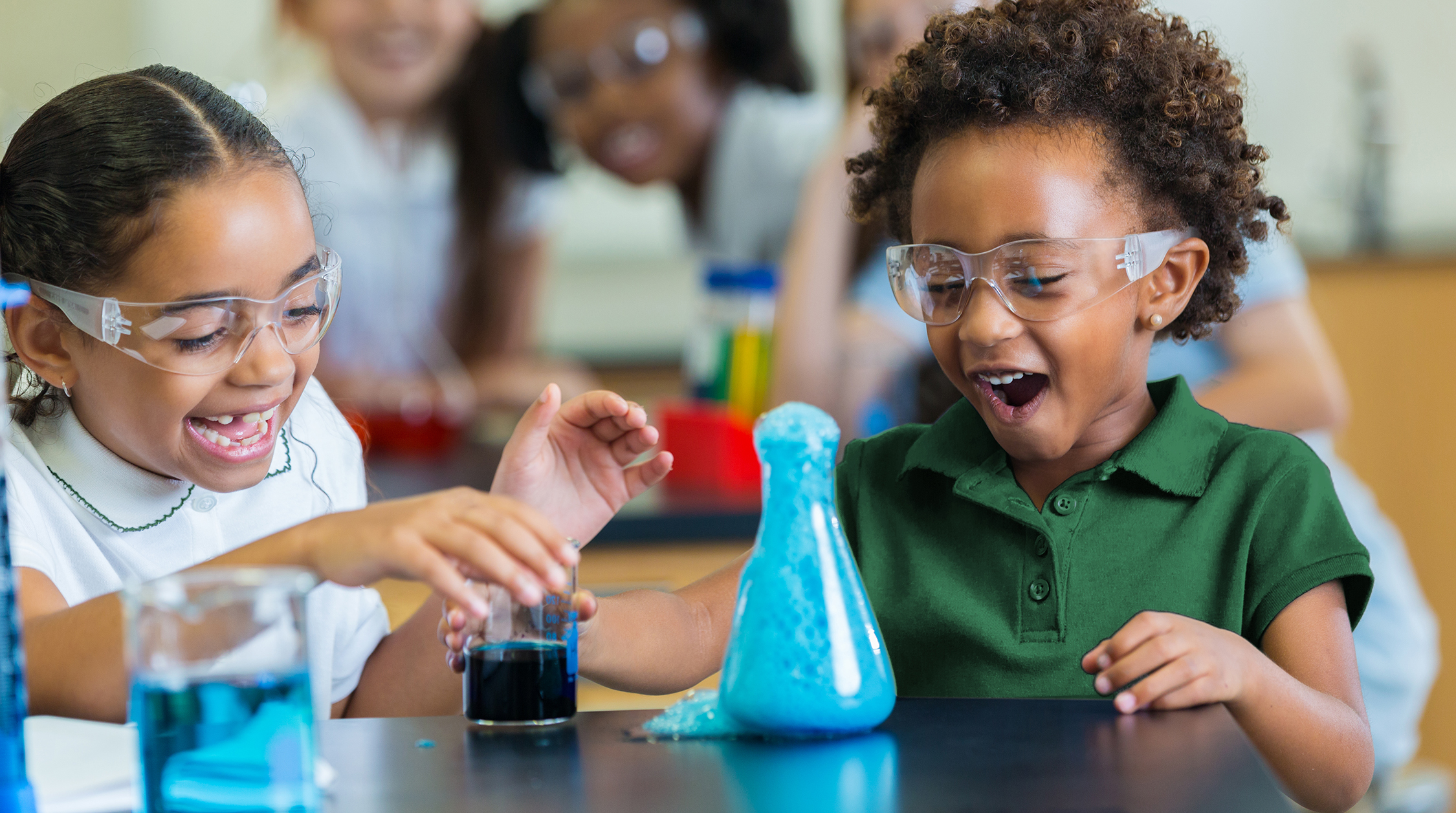 Excited school girls during chemistry experiment